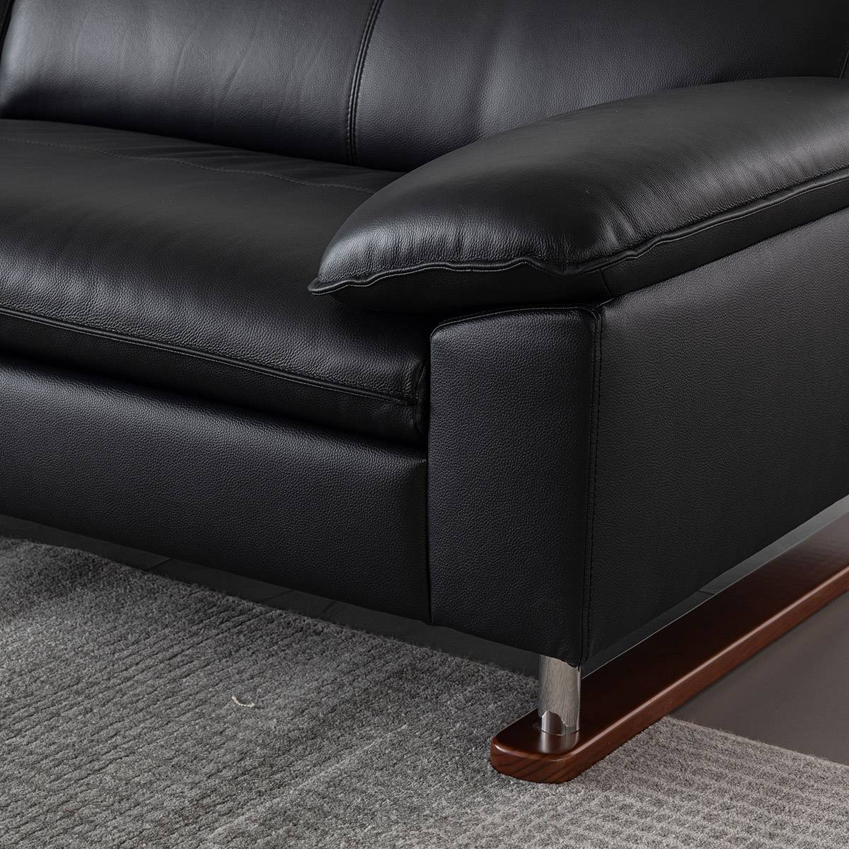 Close-up of the black leather sofa armrest and seat cushion