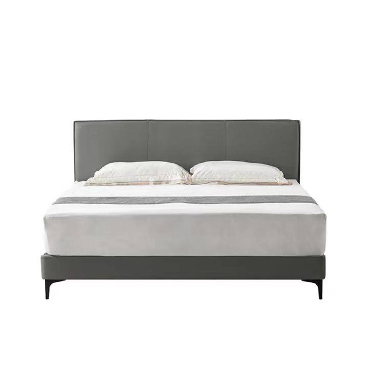Front view of a grey upholstered bed with white bedding and a grey throw