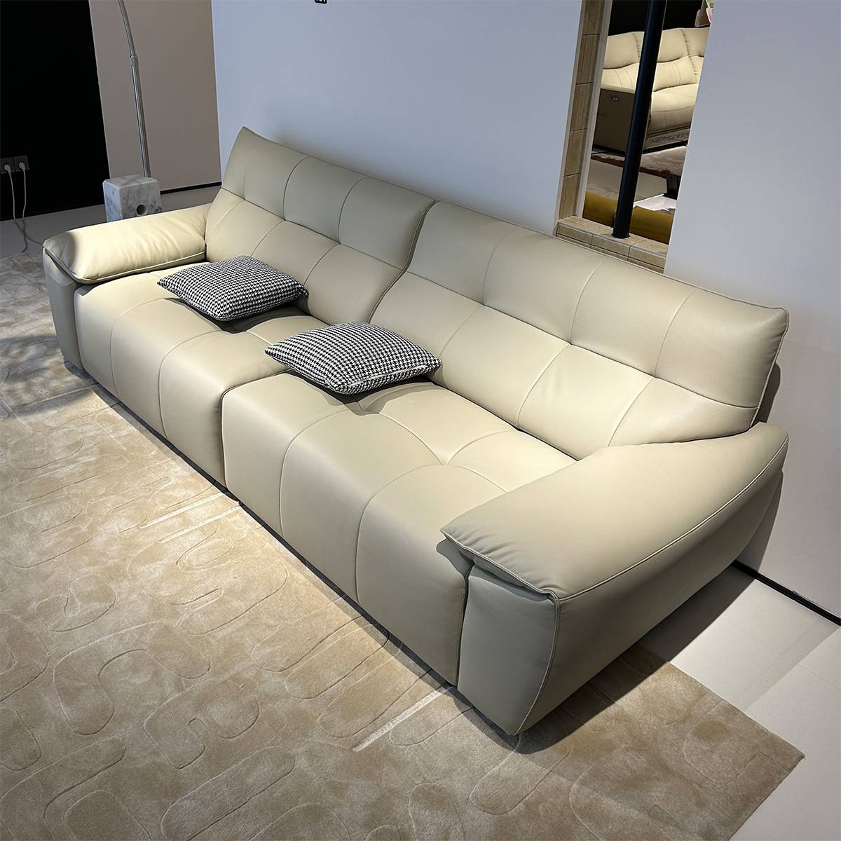 Side angle view of the beige sofa bed showing the armrest and cushions