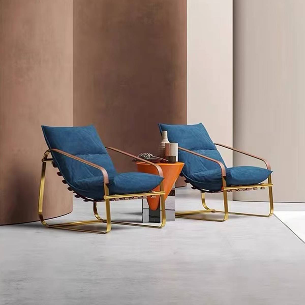 Two blue velvet lounge chairs with gold metal frames