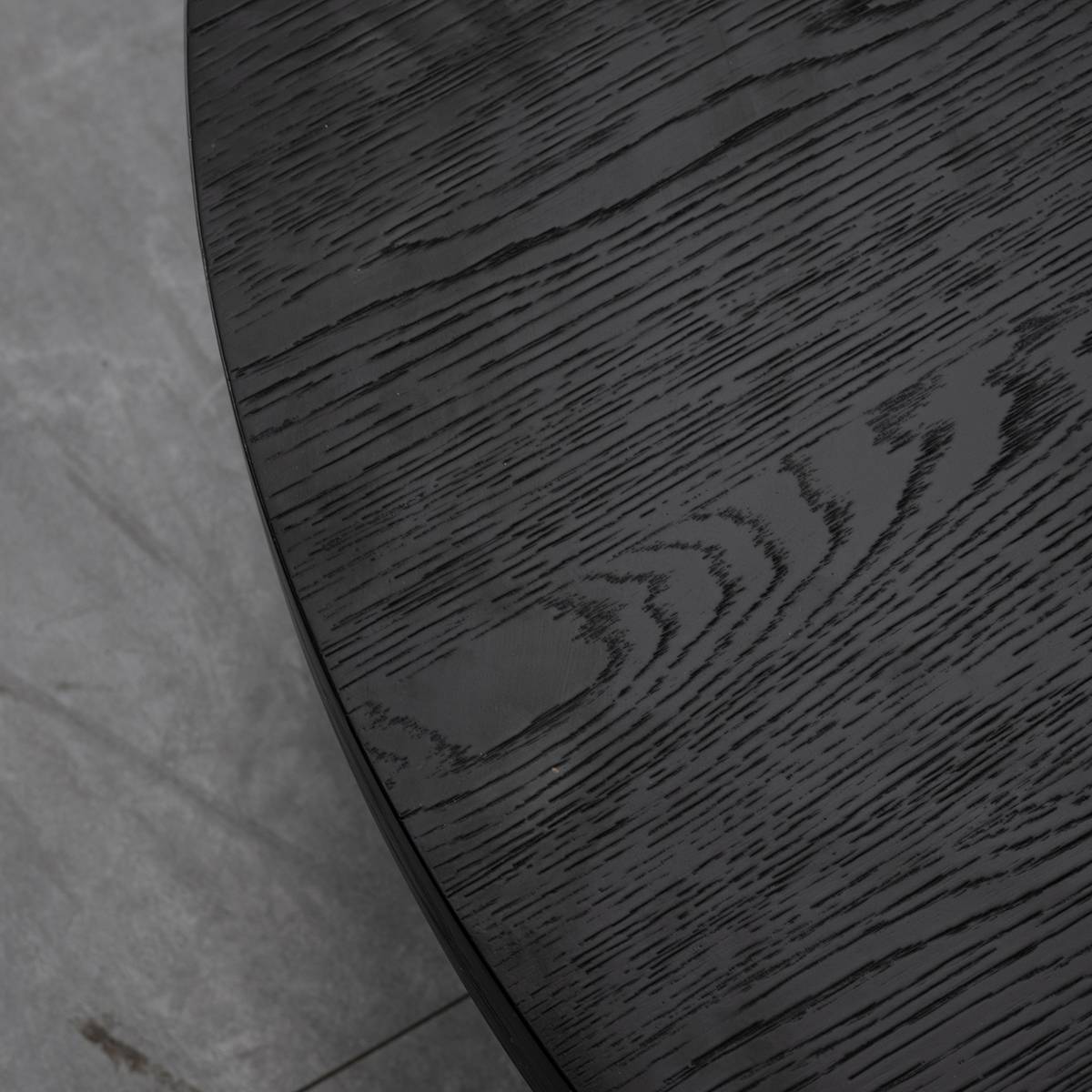 Close-up detail of the black ash wood veneer texture on the table top