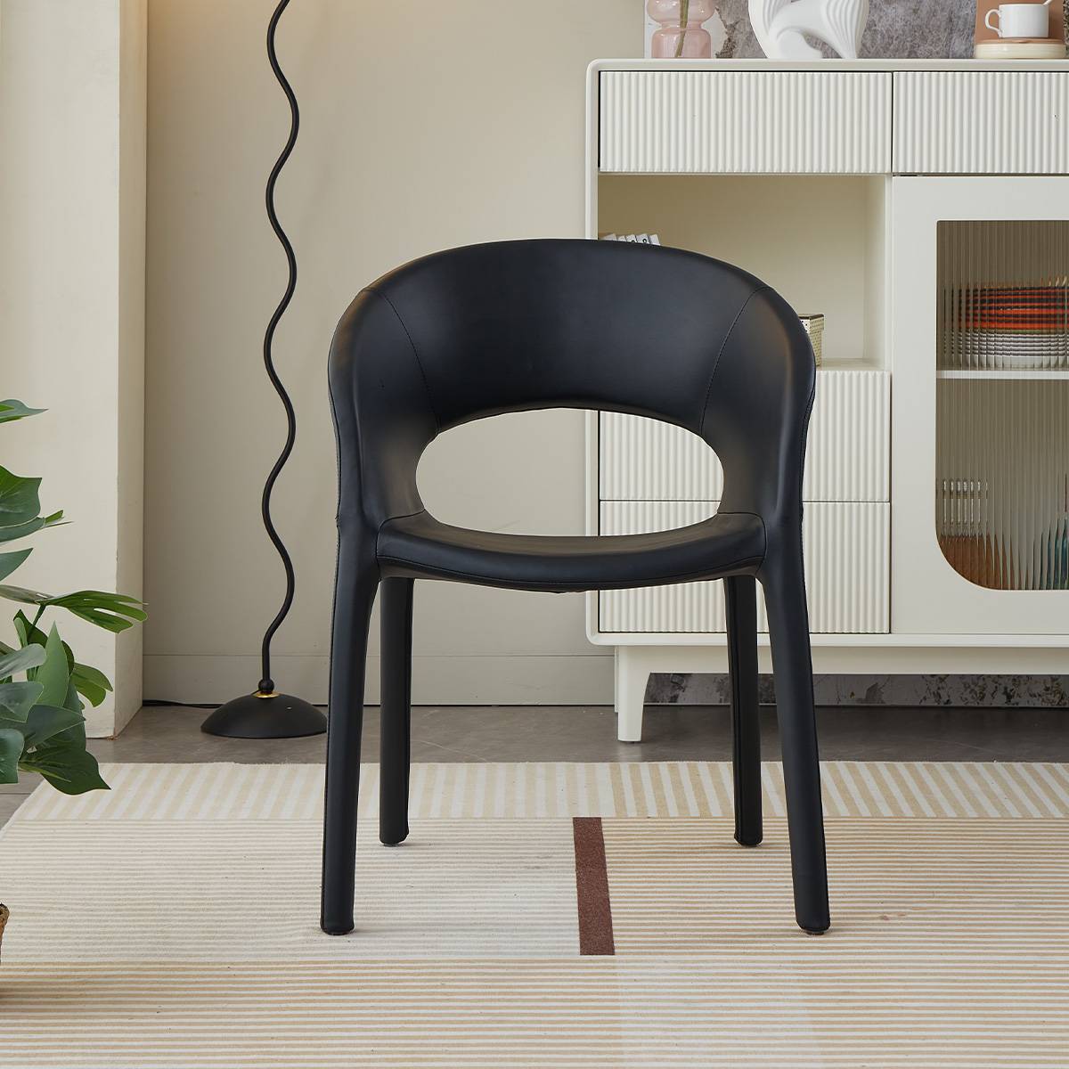 Front view of a black modern lounge chair with a curved backrest and microfiber leather upholstery.