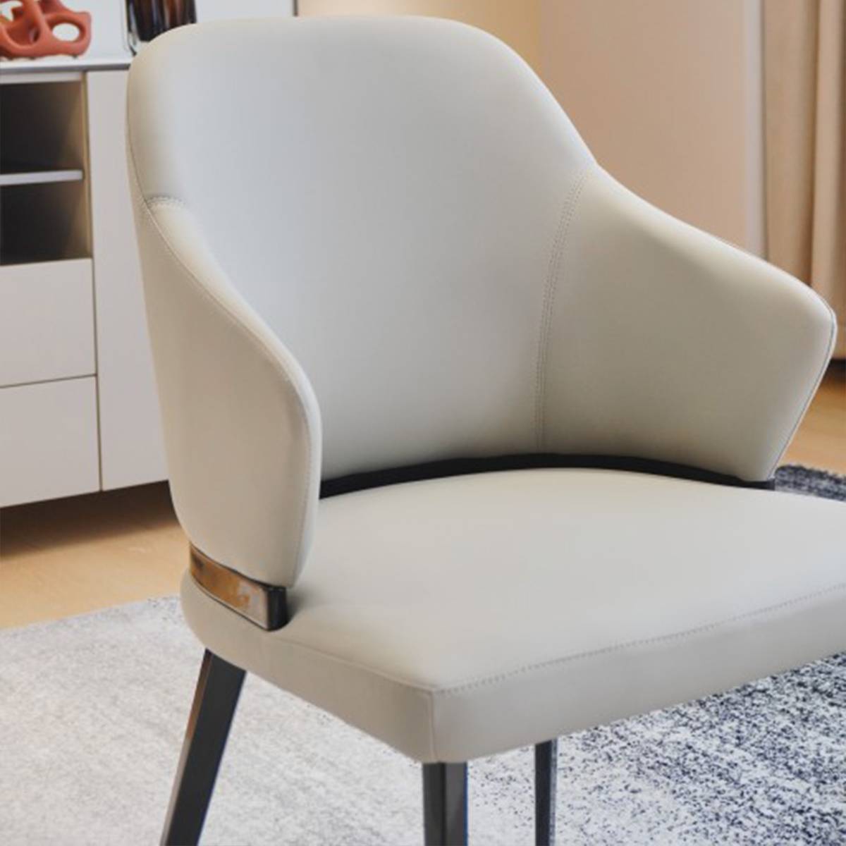 Side view of a beige dining chair with metal legs