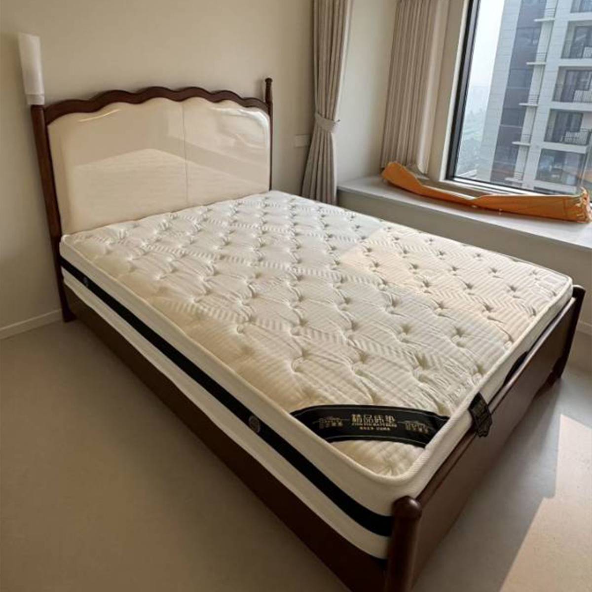 Close-up of the bed frame and mattress showing the rubber wood construction