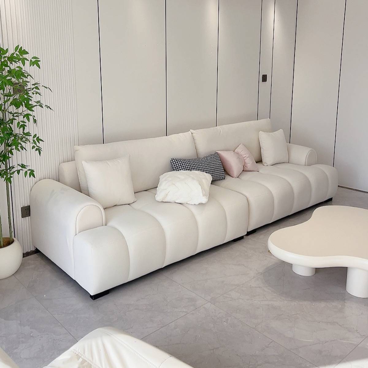 White leather tufted straight sofa in a minimalist setting