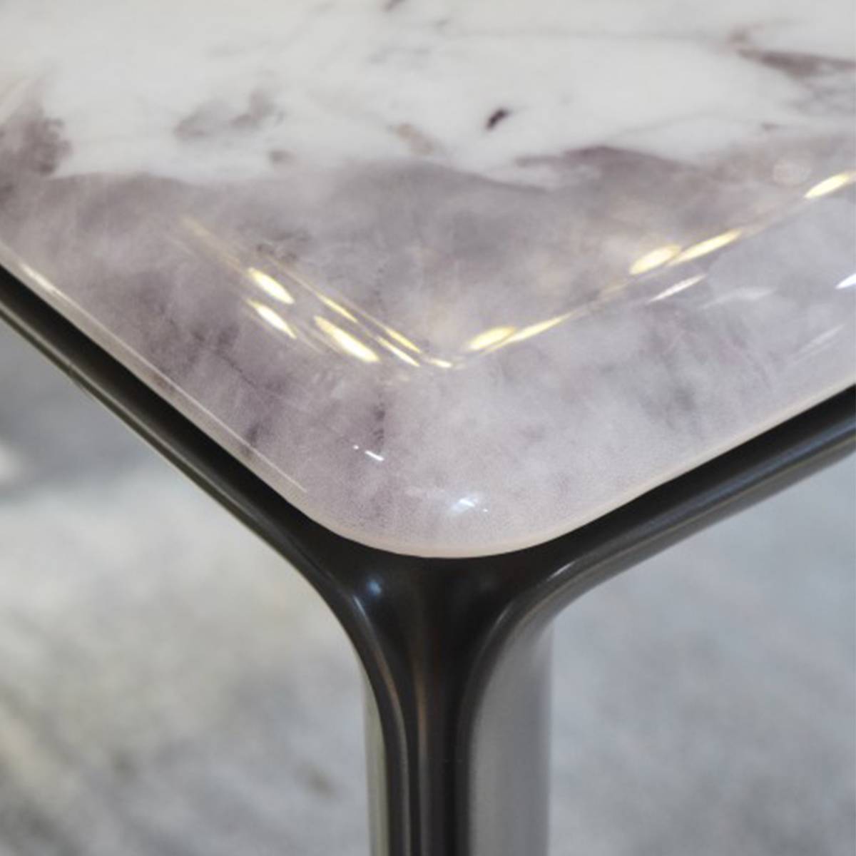 Close-up of the table corner showing the connection between the stone top and the aluminum alloy leg