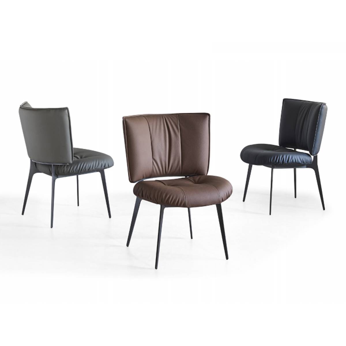 Three dining chairs in grey, brown, and black arranged in a group.