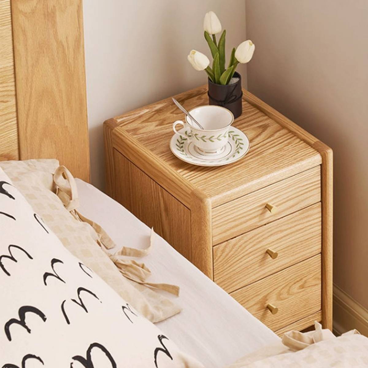 Top-down view of the bedside table with a teacup and flowers