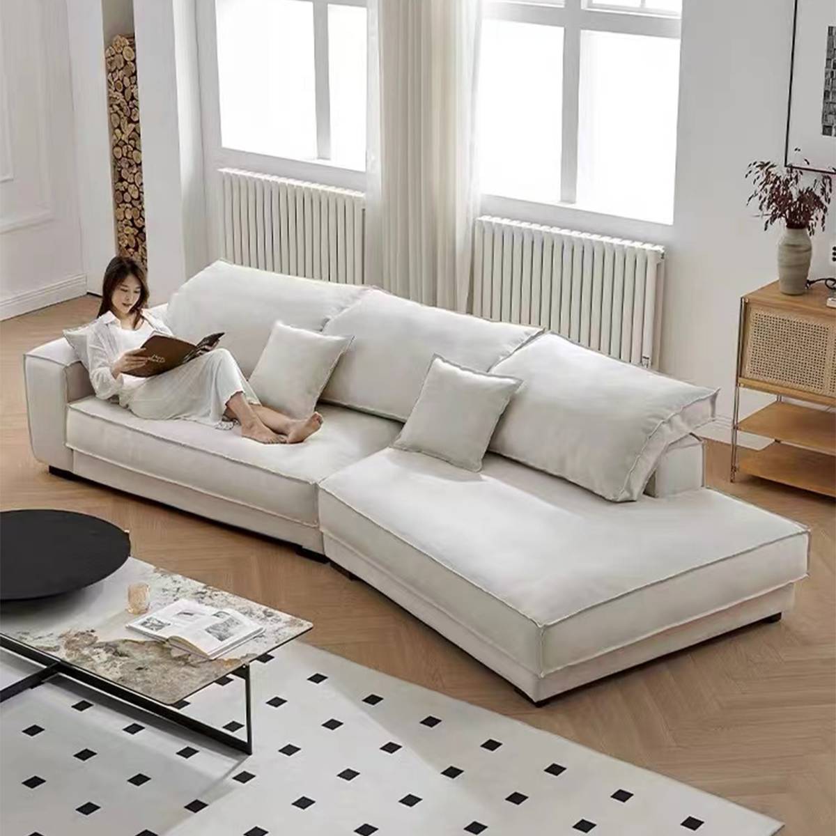 White fabric sectional sofa in a living room setting with a person reading