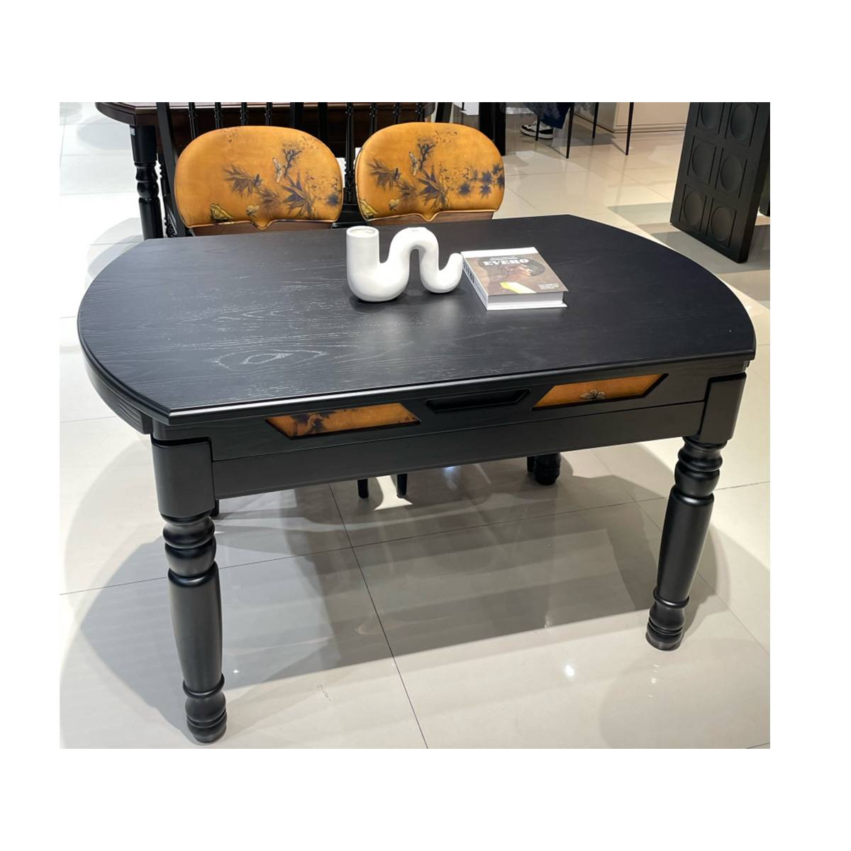 Black dining table in expanded rectangular configuration showing storage drawer