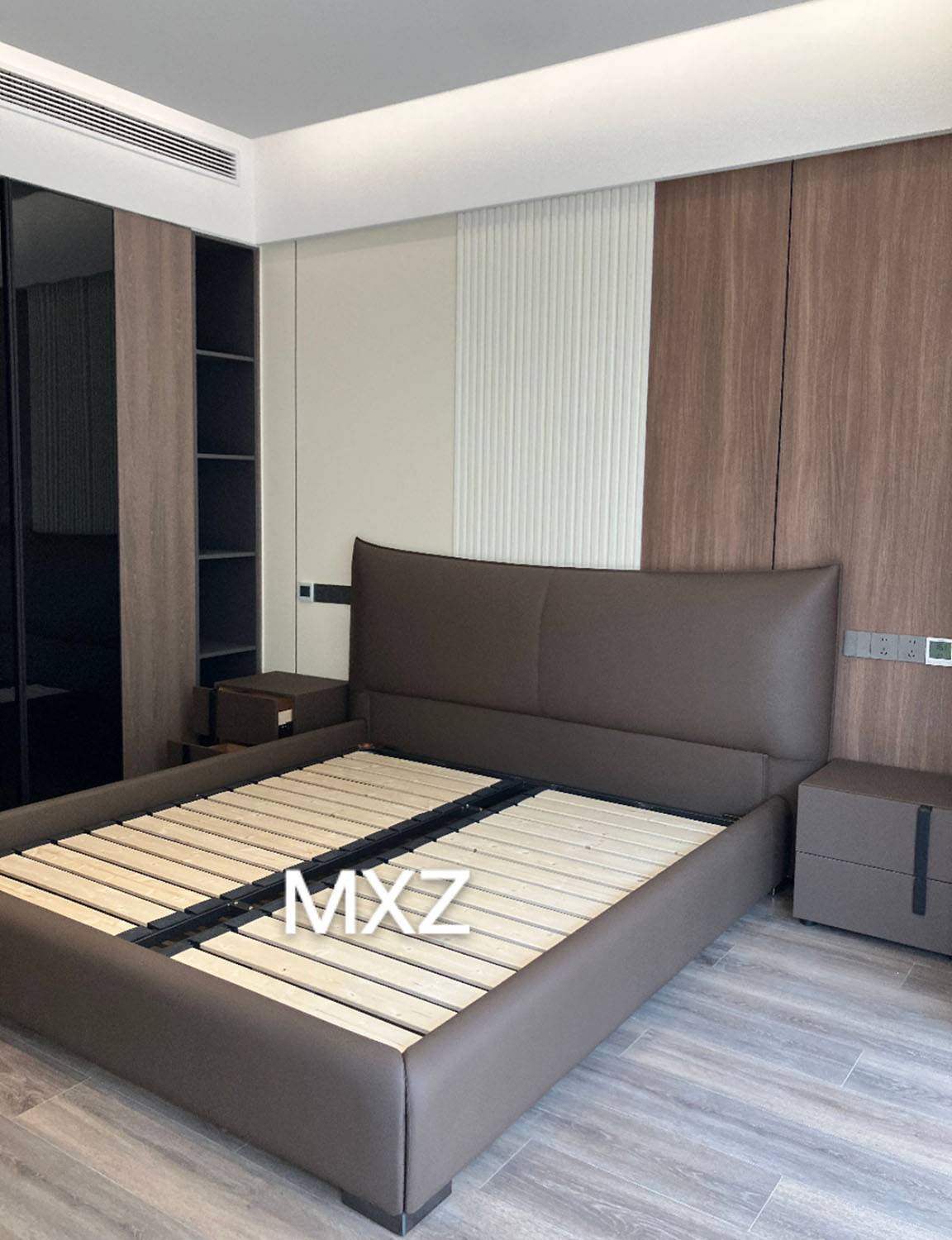 Brown upholstered bed frame with wooden slats in a modern bedroom