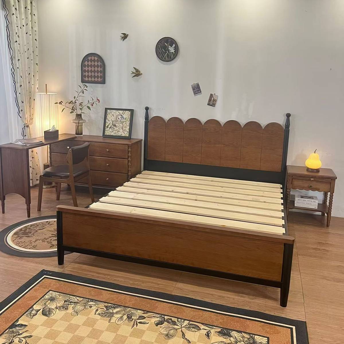 Bed styled in a bedroom setting with a desk and rug