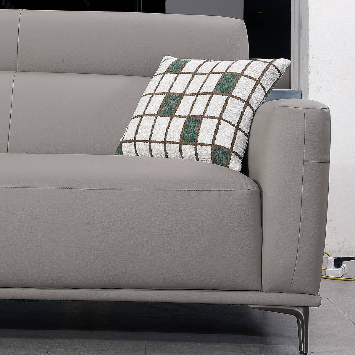 Close-up detail of the sofa armrest and patterned cushion showing fabric texture