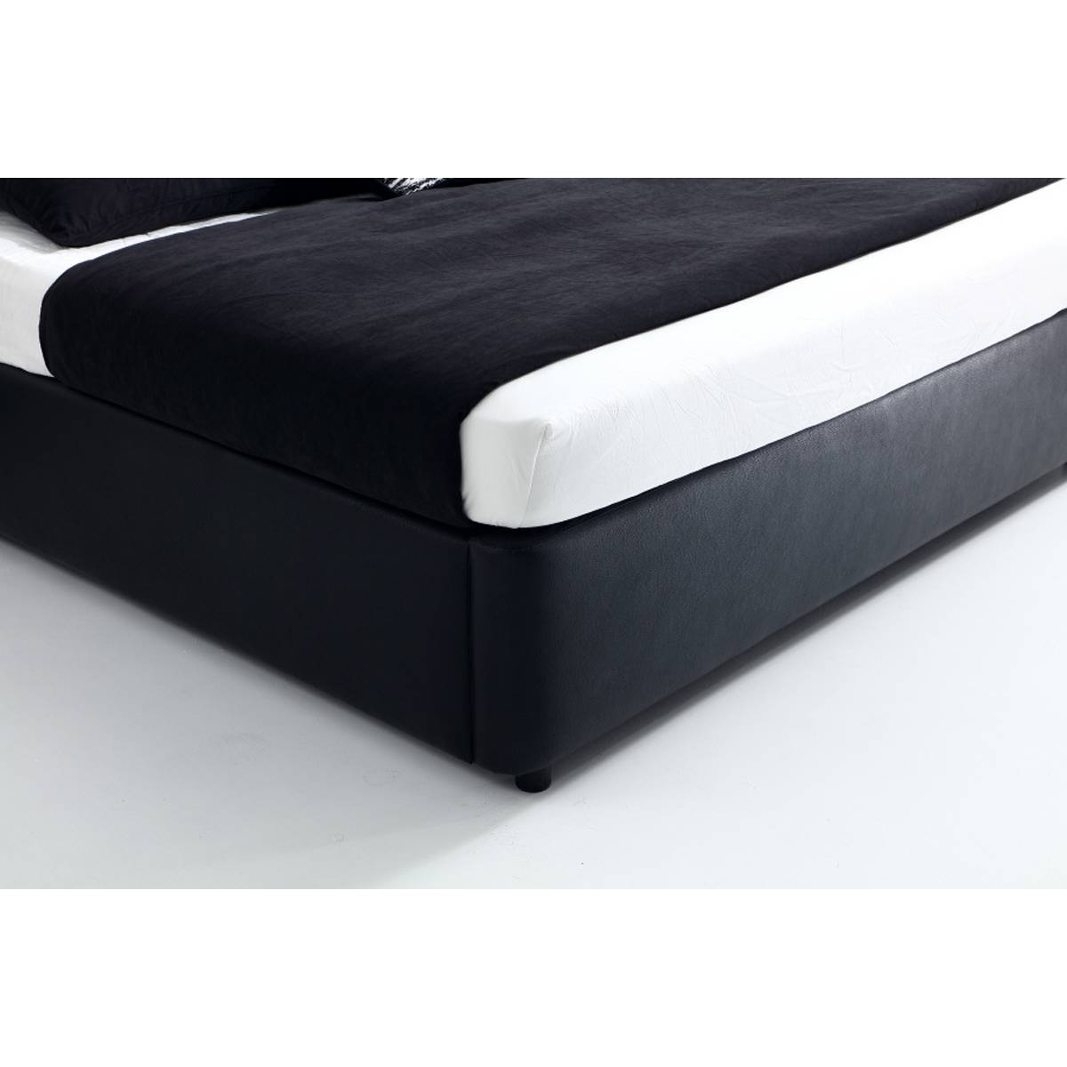 Close-up detail of the black leather bed base and corner leg