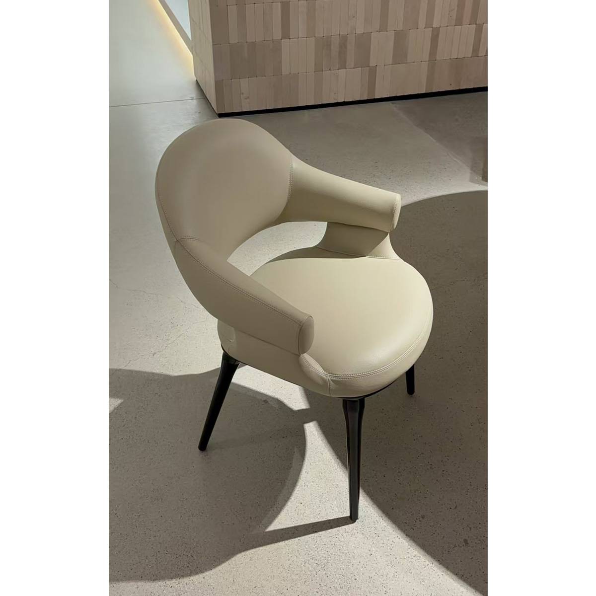 Beige modern dining chair in a showroom setting