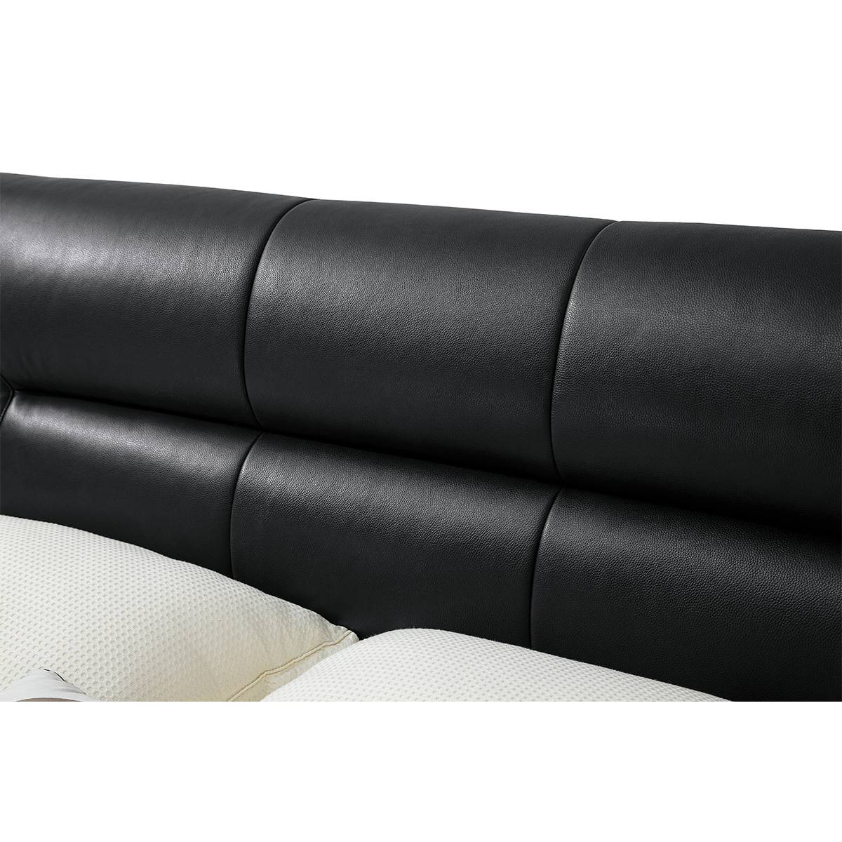 Front view of black leather bed with white bedding and side tables