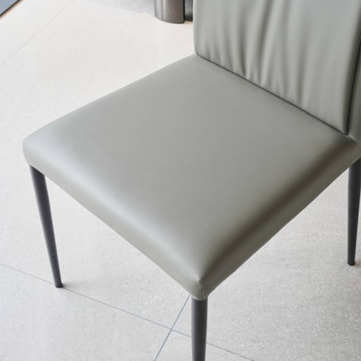 Full view of the grey faux leather dining chair with metal legs