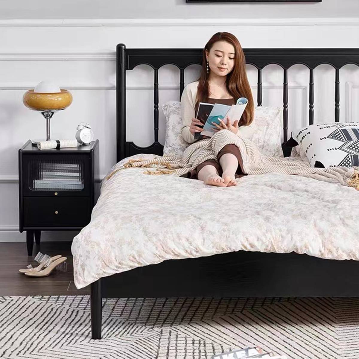 Bedroom setup featuring the black bed with matching nightstands and decor