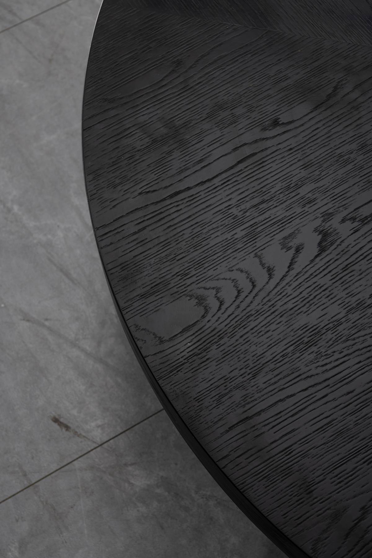 Close-up detail of the black wood grain texture on the table surface