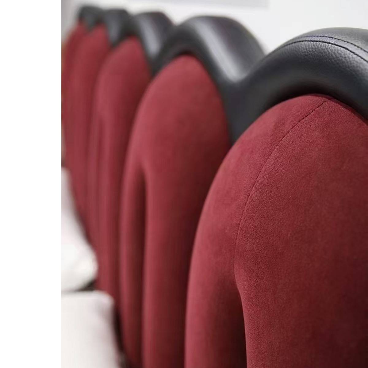 Close-up view of the red velvet tufted headboard with black eco-leather trim