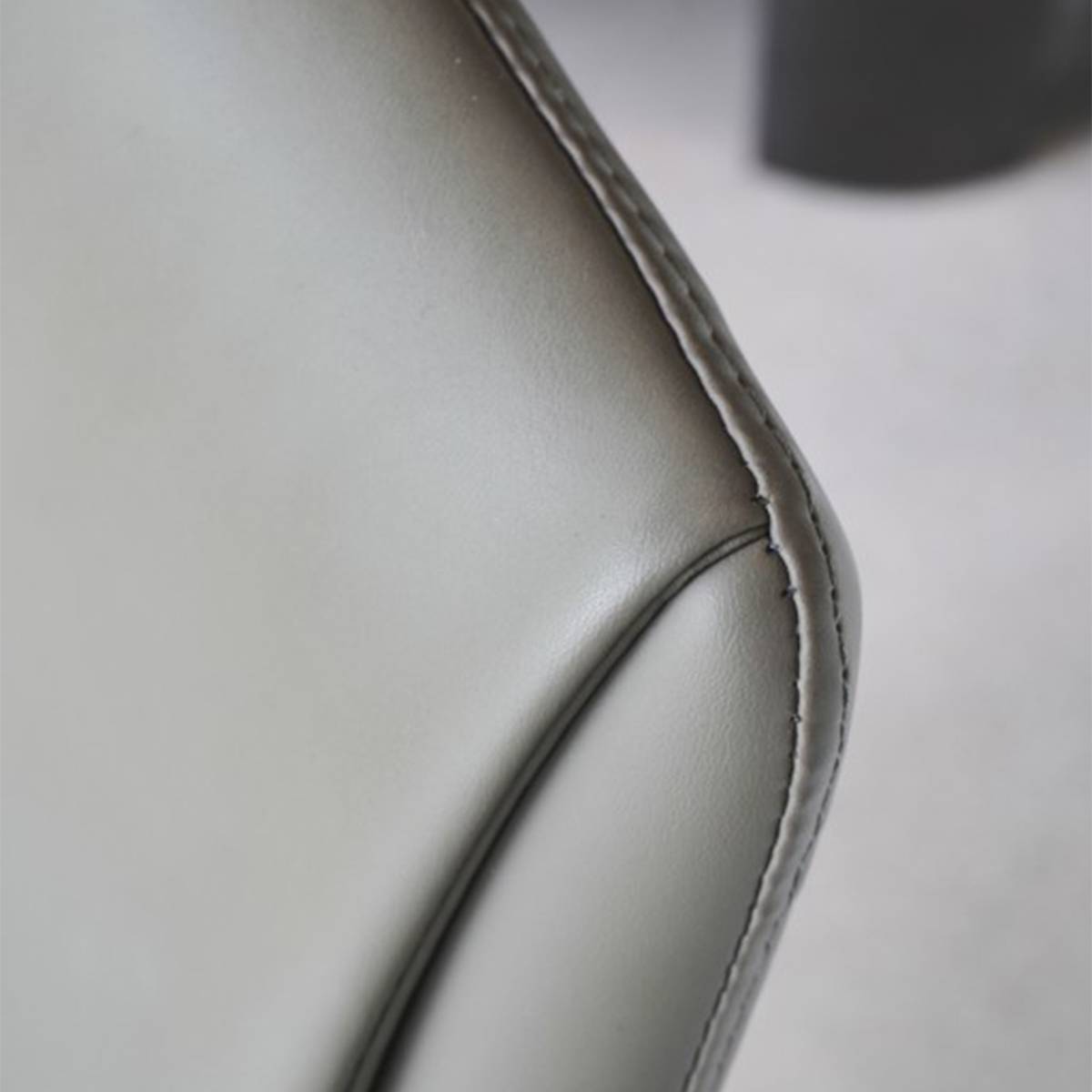 Close-up view of the faux leather stitching and corner detail of the dining chair