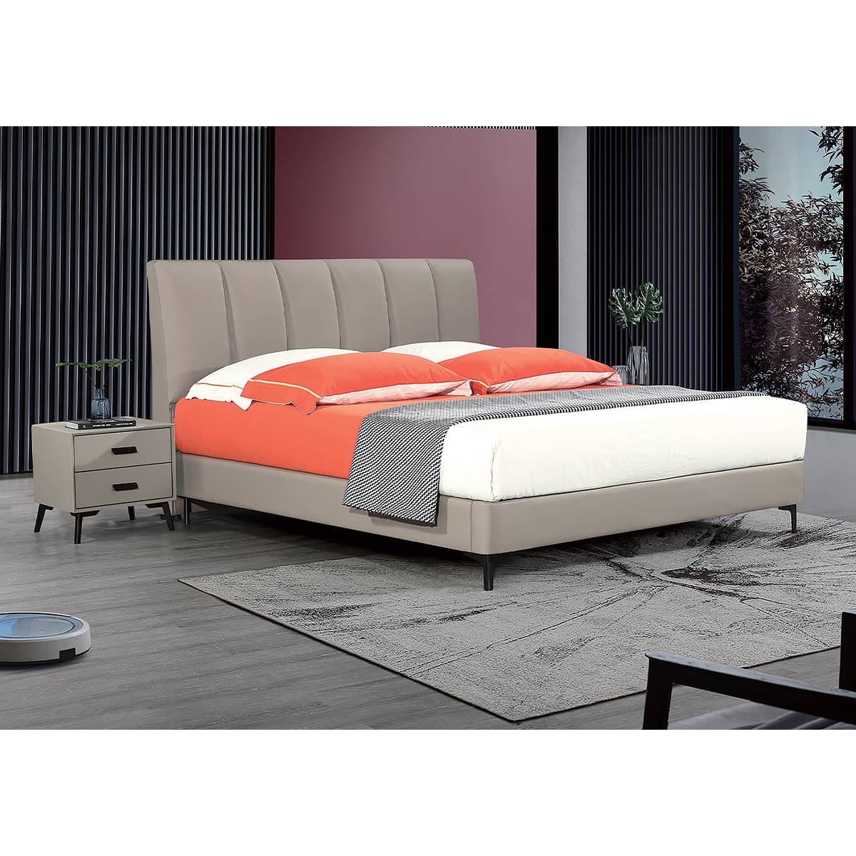 Grey upholstered bed with orange bedding in a modern bedroom setting