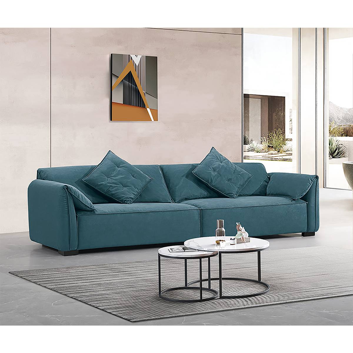 Teal velvet Elephant Ear sofa displayed in a bright living room with abstract art.