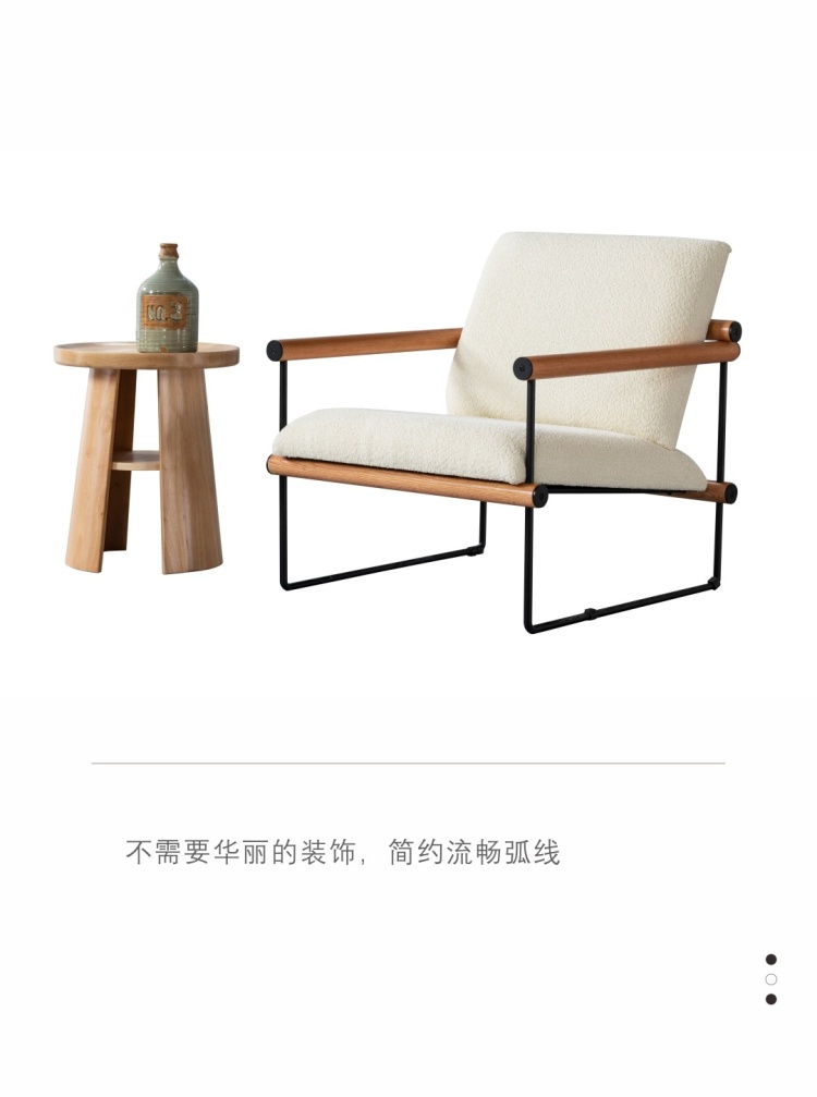 Side view of the C266 lounge chair with sheepskin upholstery and wooden armrests next to a wooden side table.
