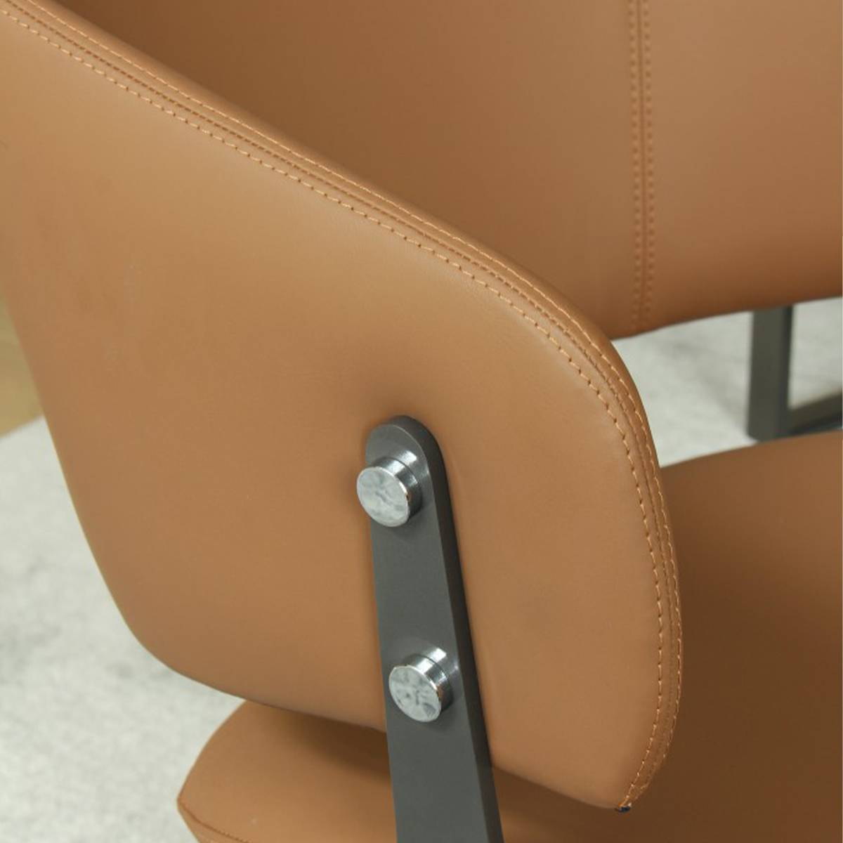 Close-up detail of the orange PU leather upholstery and carbon steel frame connection of the B10 dining chair.