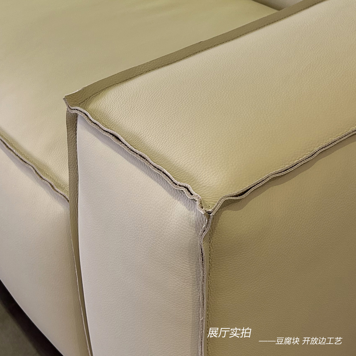 Close-up detail of the sofa's open-edge stitching and leather texture