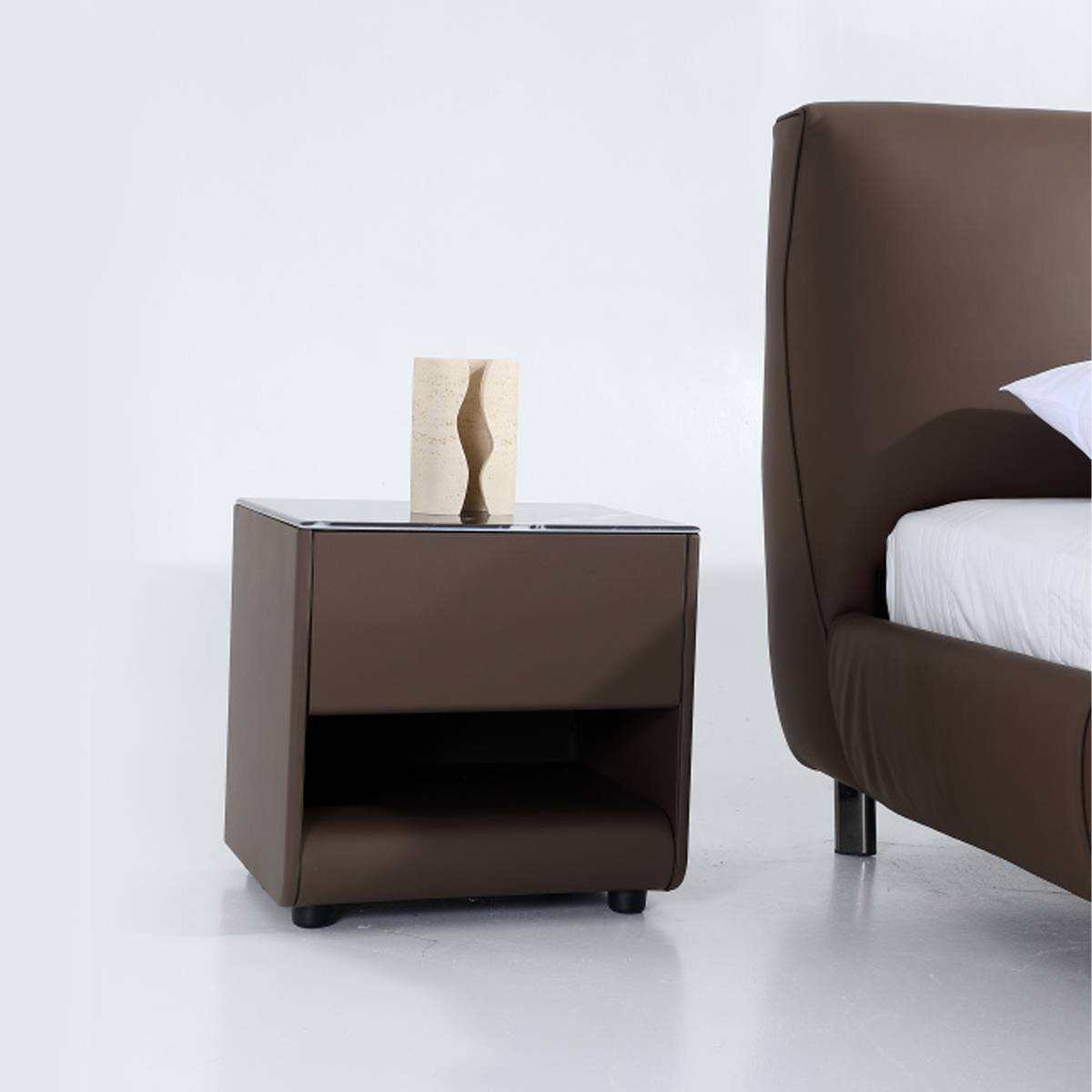 Close-up detail of the brown leather bedside table with a decorative vase