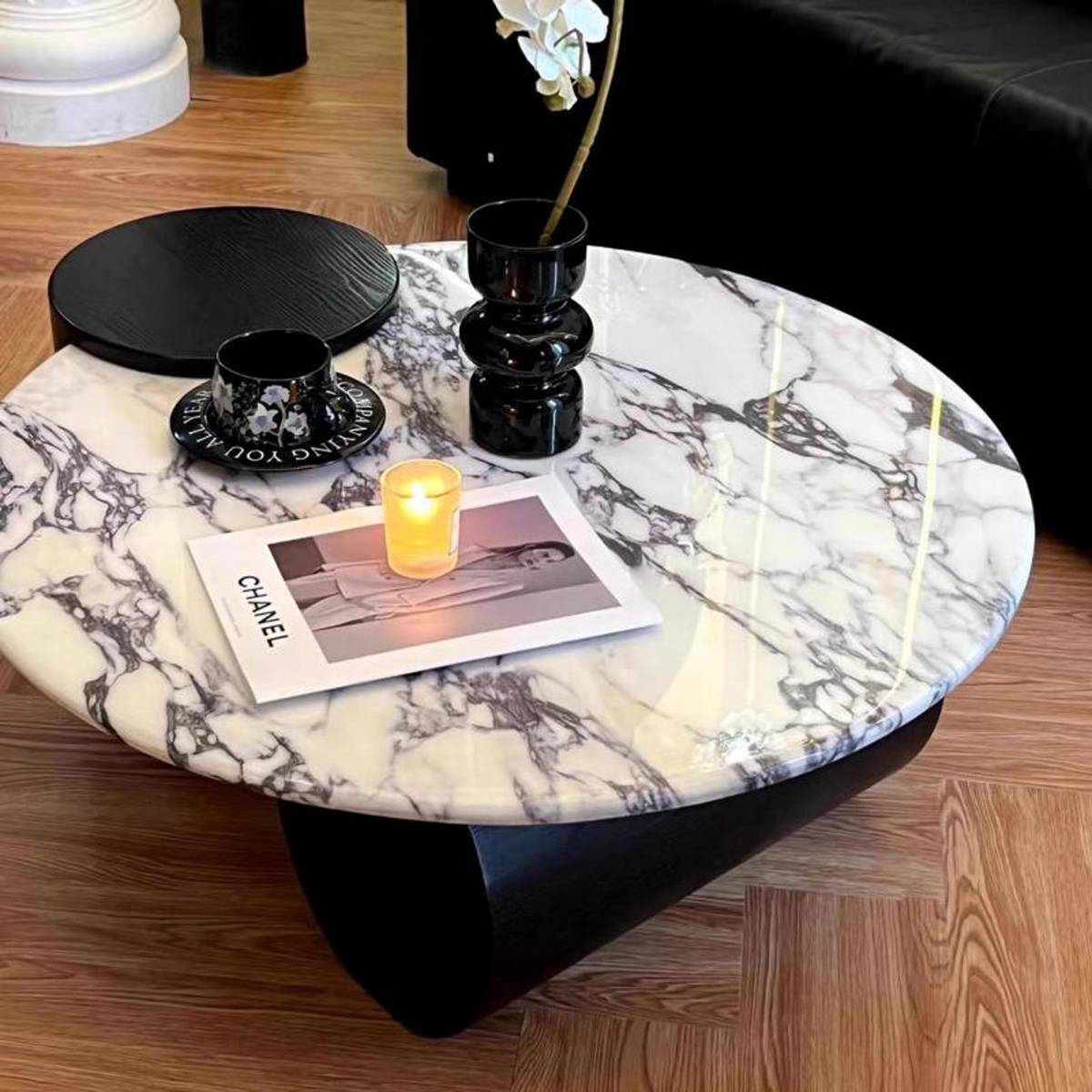 Side view of the marble coffee table showing the curved base structure and marble texture.