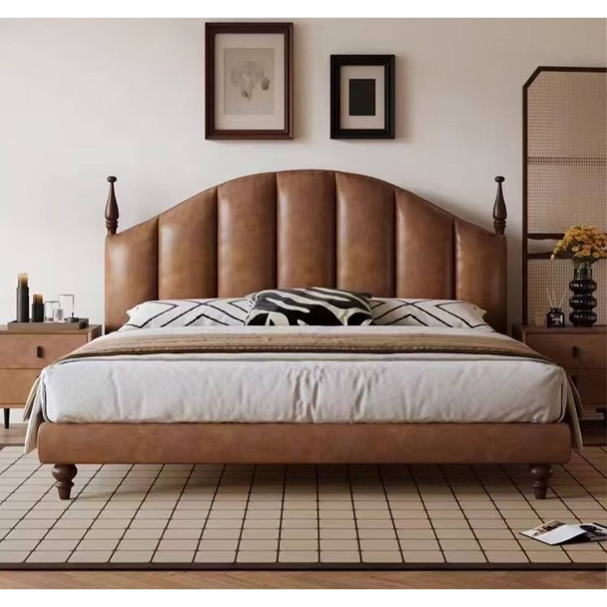 Front view of the brown leather bed with patterned pillows and bedside tables