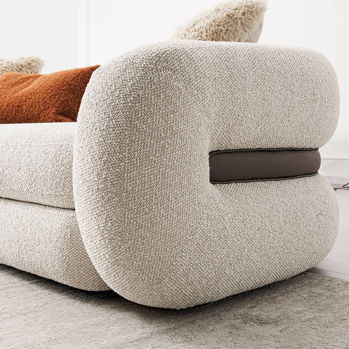Detail of the sofa armrest showing the leather accent strip