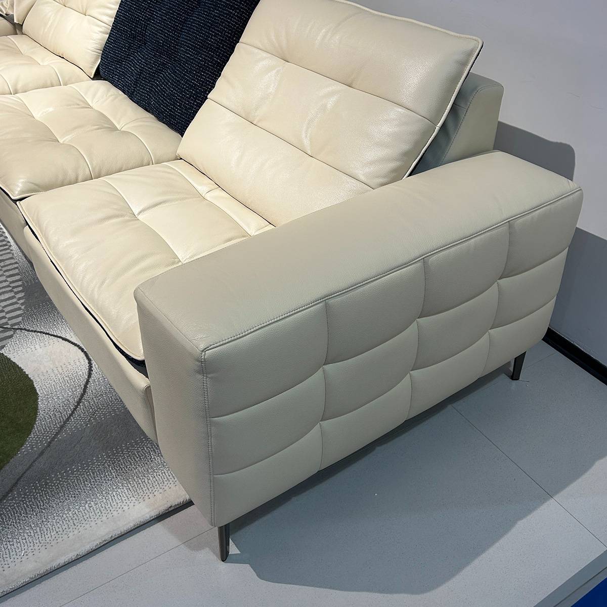 Close-up detail of the sofa armrest and tufted leather texture