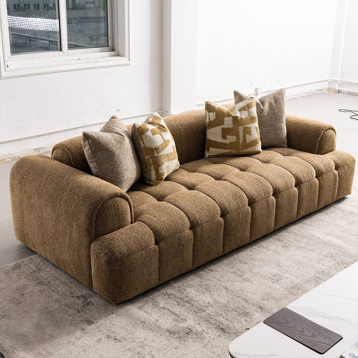 Brown fabric sofa placed in a living room setting with a rug