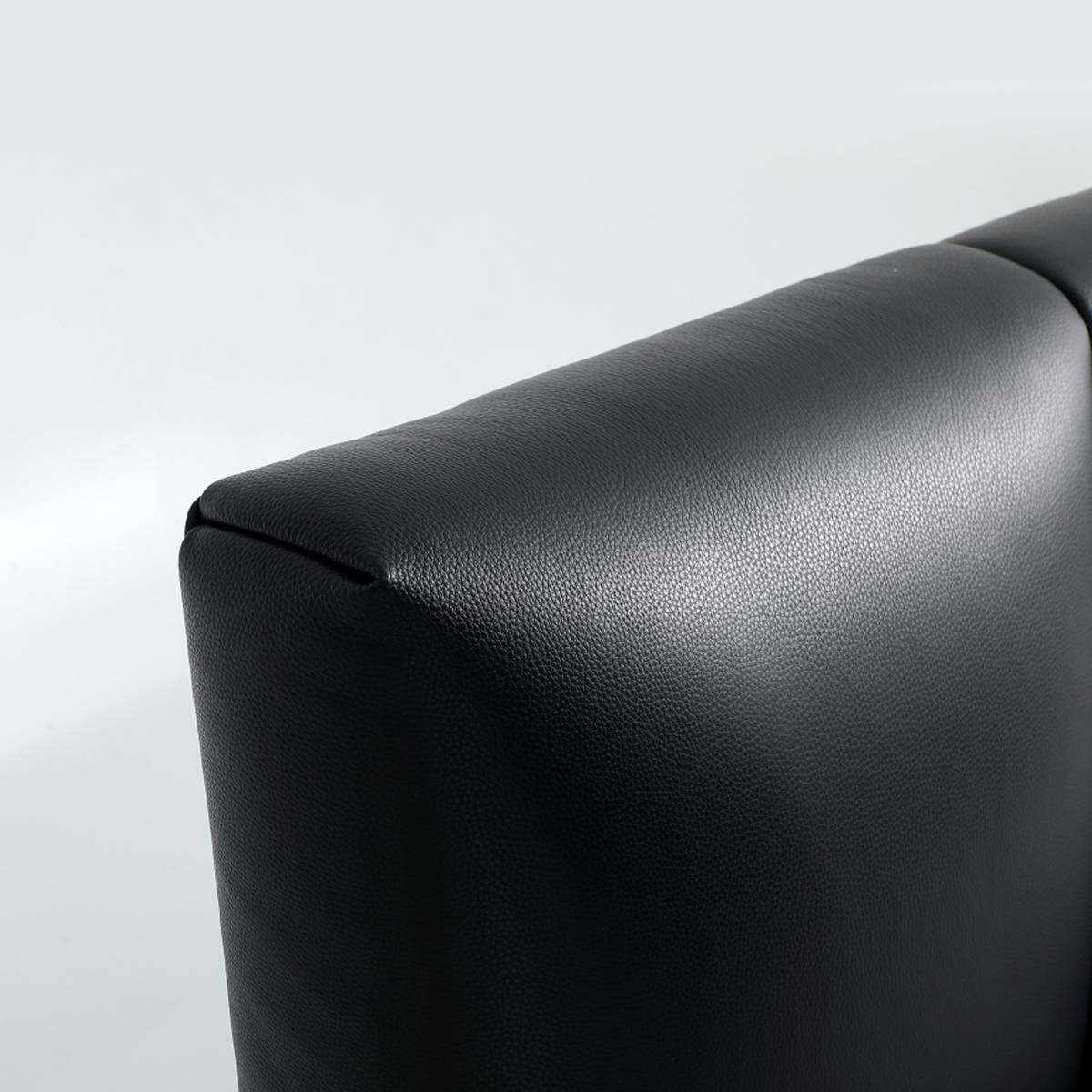 Close-up detail of the black top-grain cowhide leather upholstery showing texture and stitching
