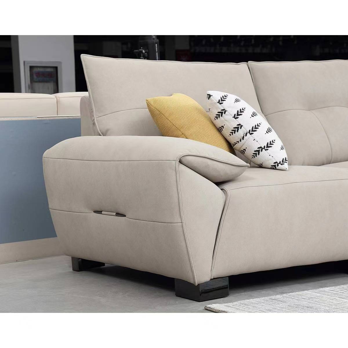 Close-up of the sofa armrest and back cushions with decorative pillows