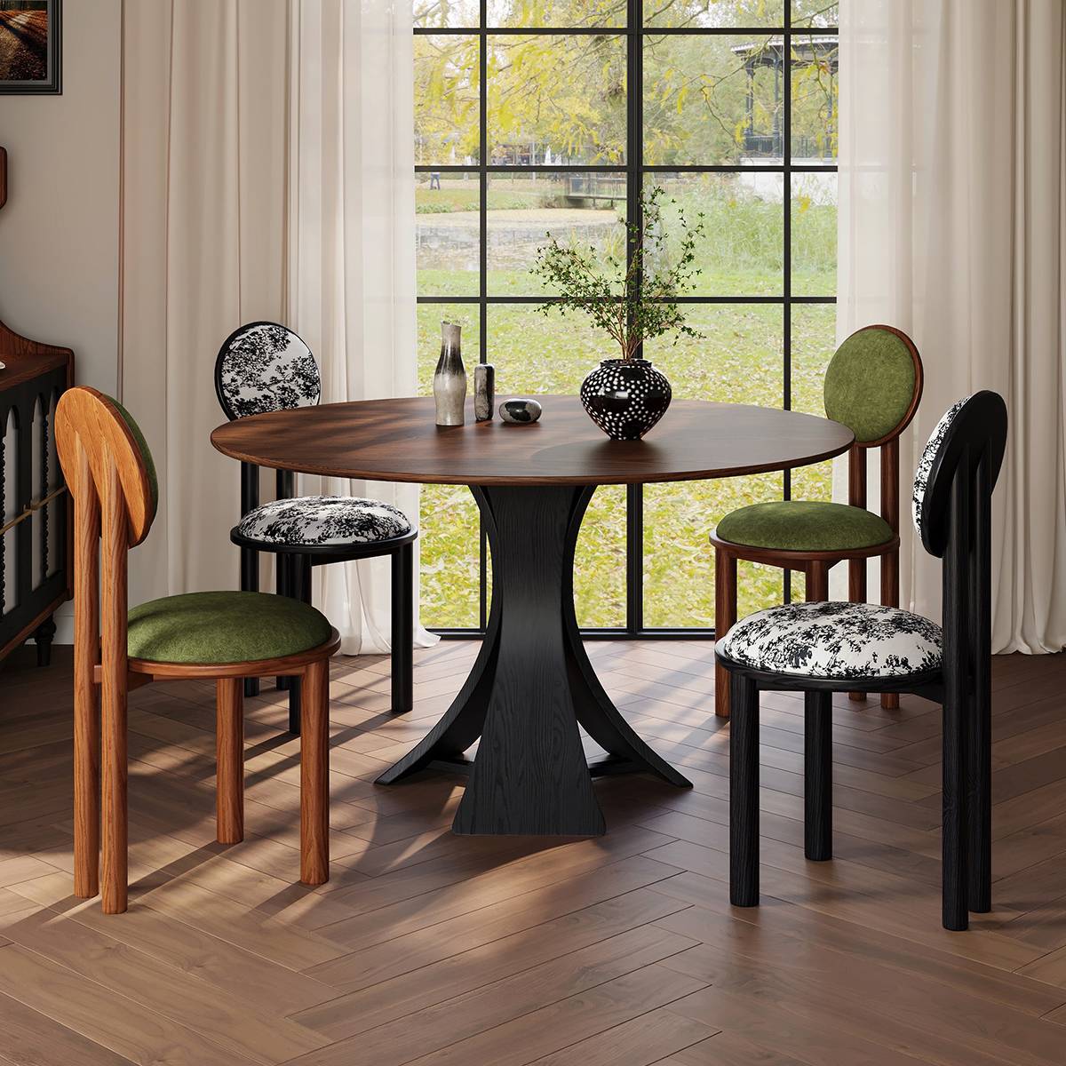 Round dining table with a black curved base and mixed style chairs, placed near a window with natural light.