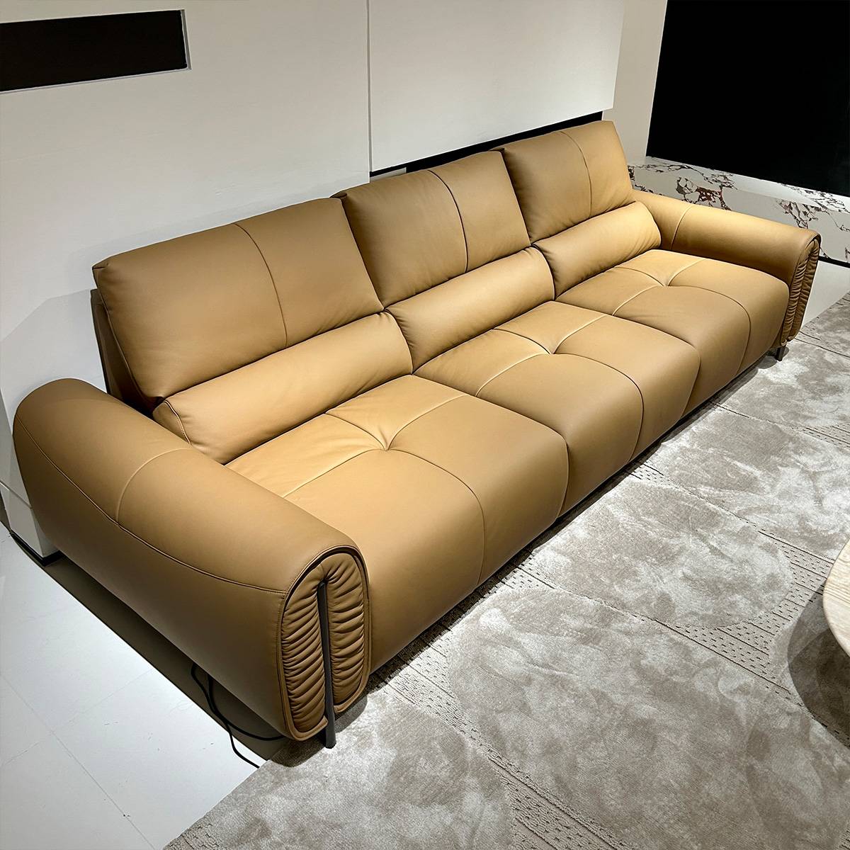 Side angle view of the leather sofa showing the armrest detail