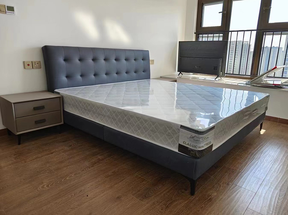 Blue upholstered bed in a bedroom setting with a mattress
