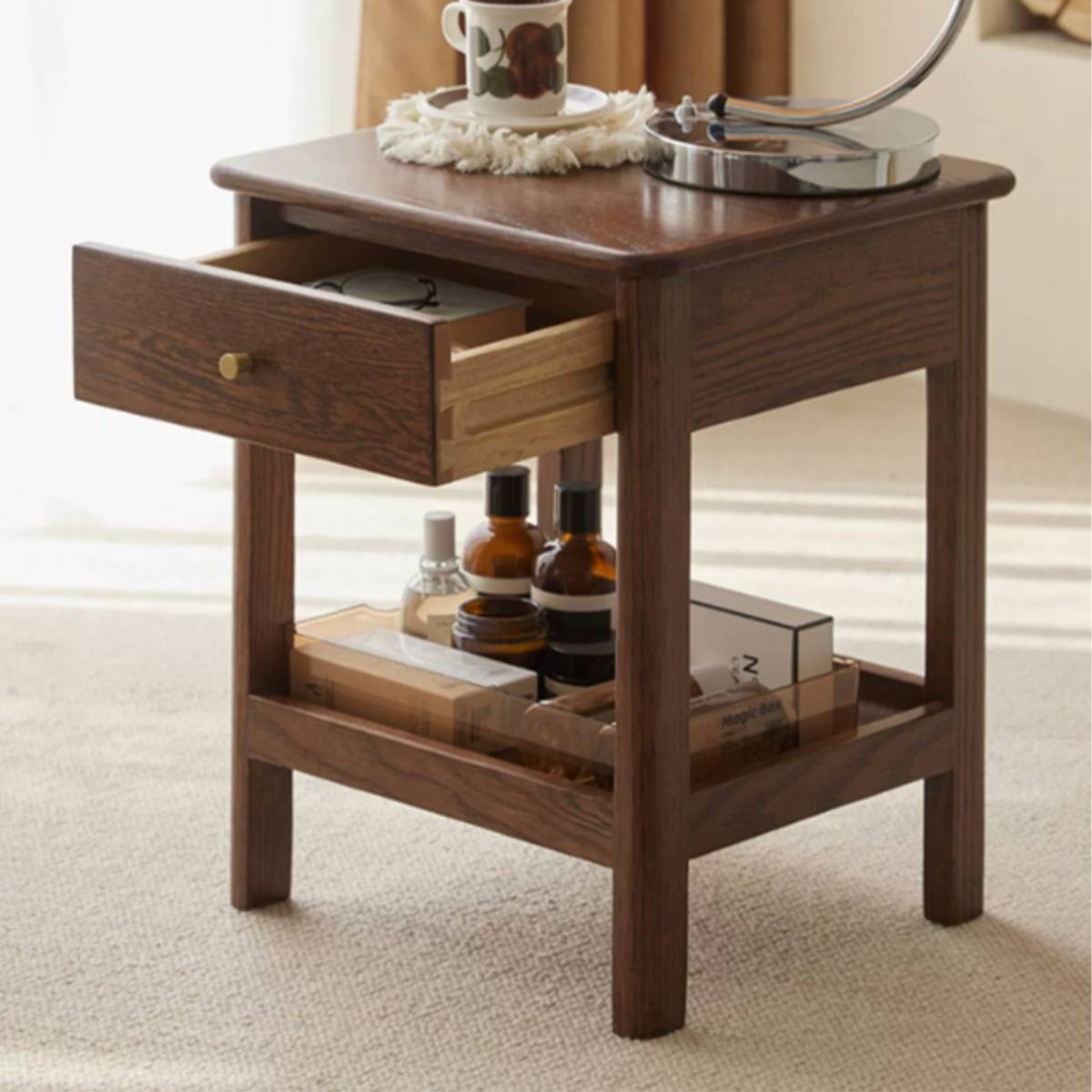 Close-up of the wooden bedside table with the drawer open, showing storage capacity.