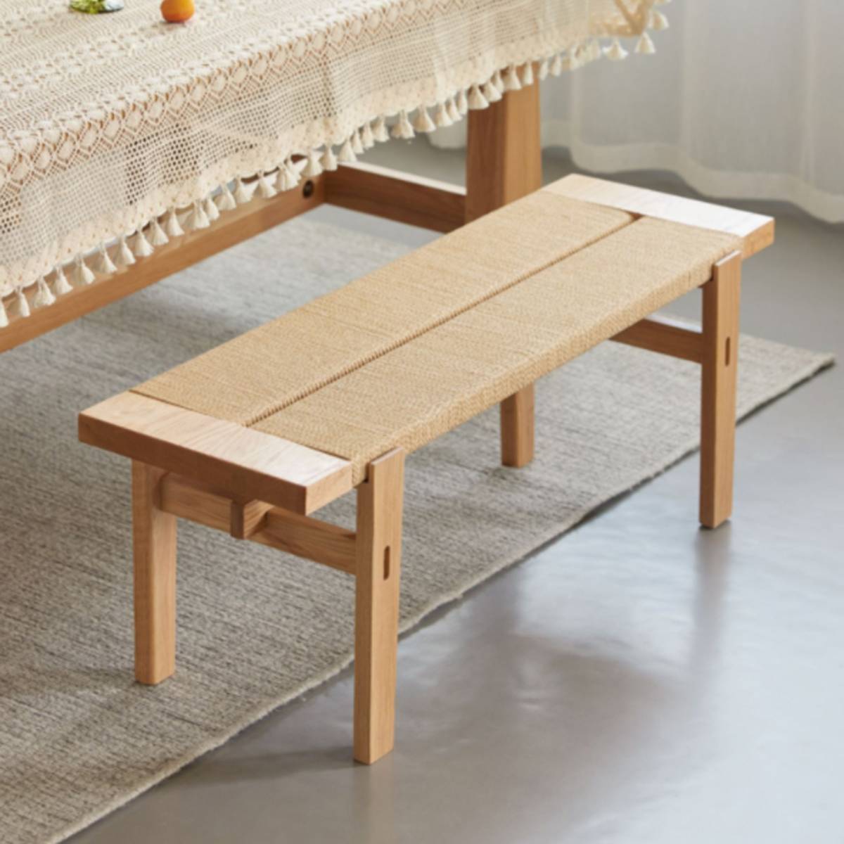 Side view of the wooden bench showing the frame construction and woven seat detail