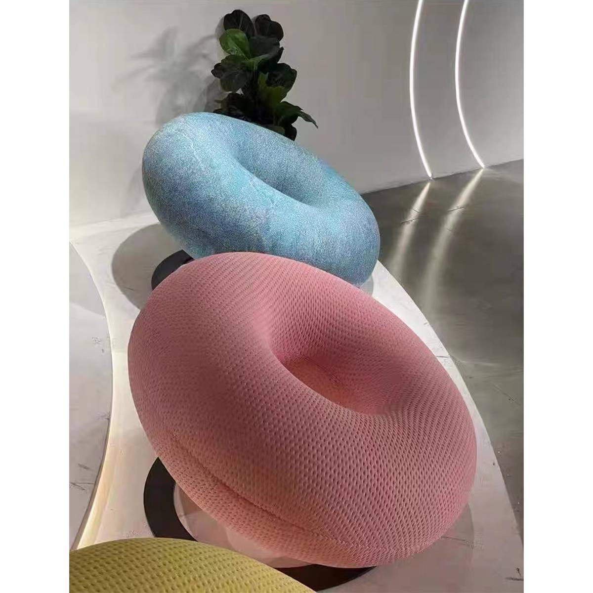 Blue, pink, and yellow donut leisure chairs in a modern interior