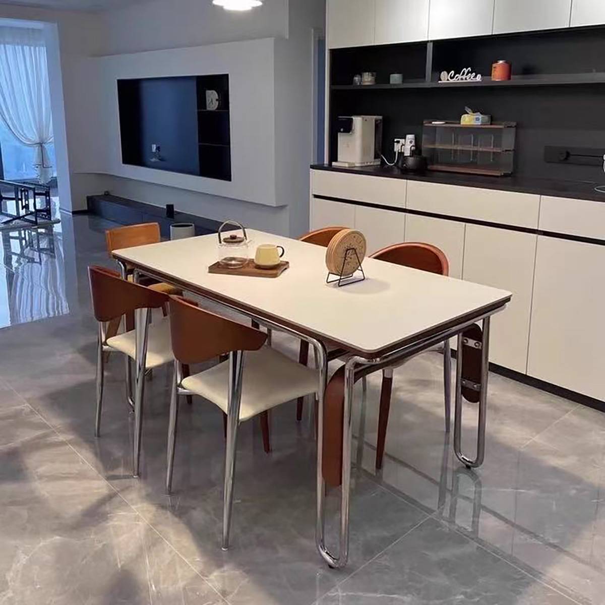 White sintered stone dining table with stainless steel legs in a modern apartment