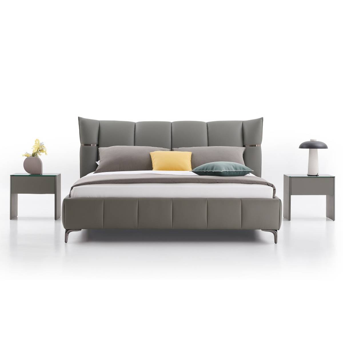 Front view of the grey upholstered bed with yellow and green accent pillows