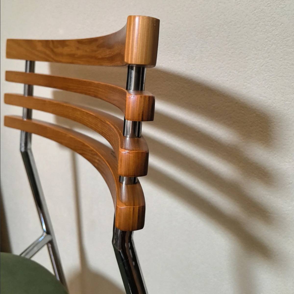 Close-up detail of the wooden slats and metal frame connection on the chair back