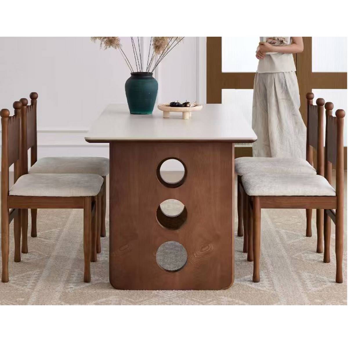 Front view of the dining table showing the white top and walnut base with circular cutouts