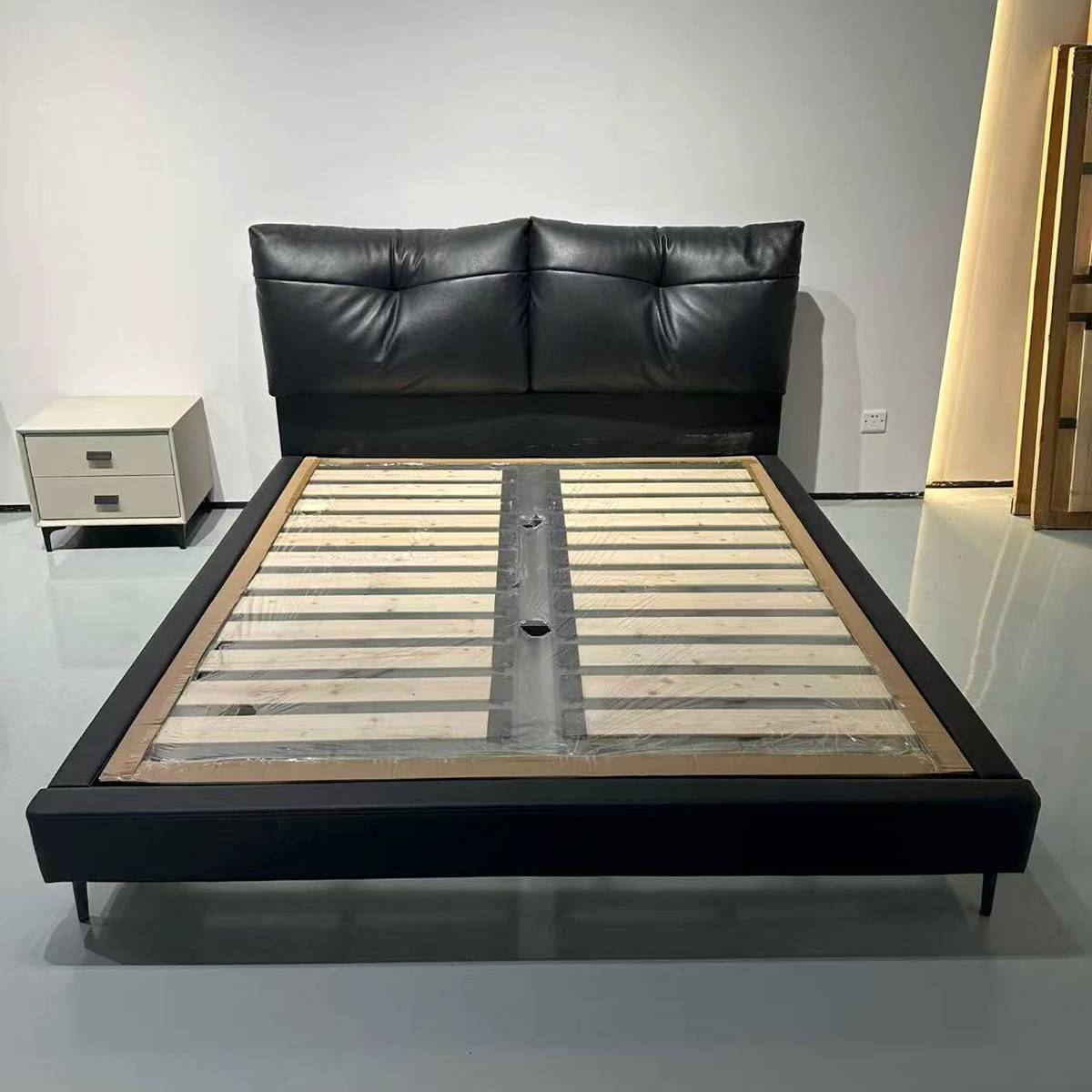 Front view of bed frame with wooden slats and side table