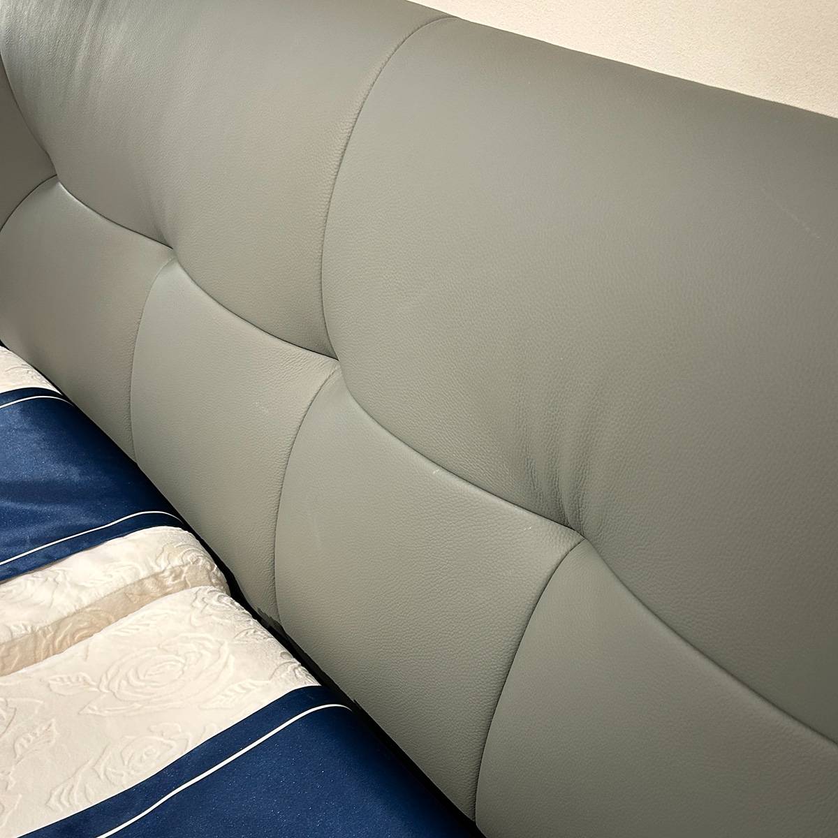Detail shot of the leather texture and stitching on the headboard
